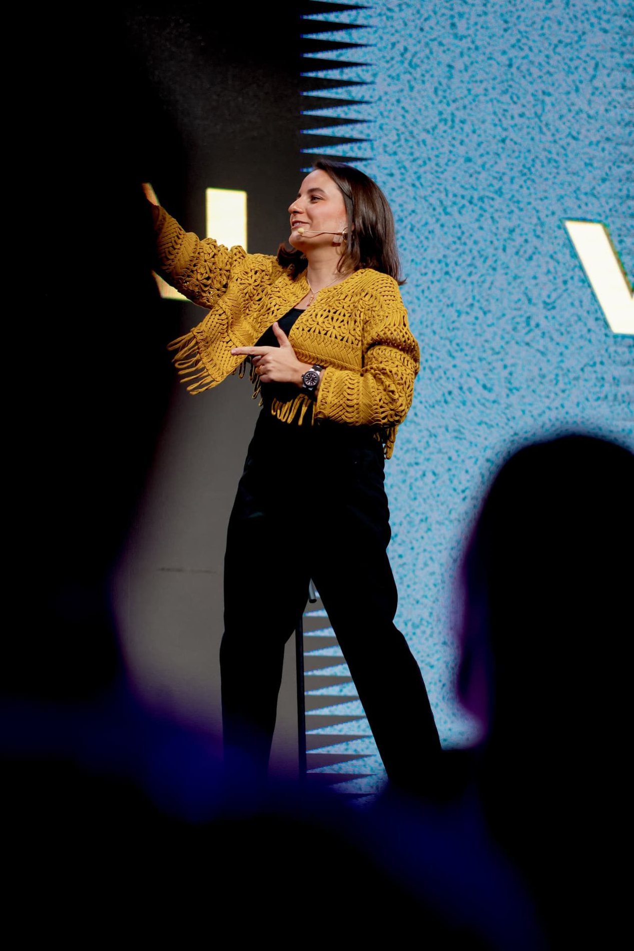 Steph Daguer en escenario con el brazo levantado durante una conferencia